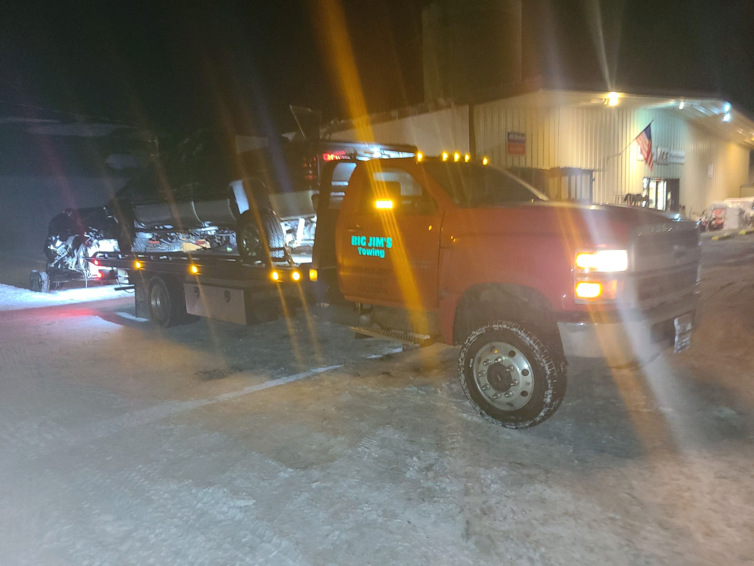 Big Jim's Flatbed Tow Truck at night