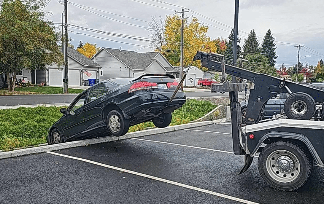 Big Jim's Wrecker Truck Pulling Honda Accord out of swale in Spokane parking lot