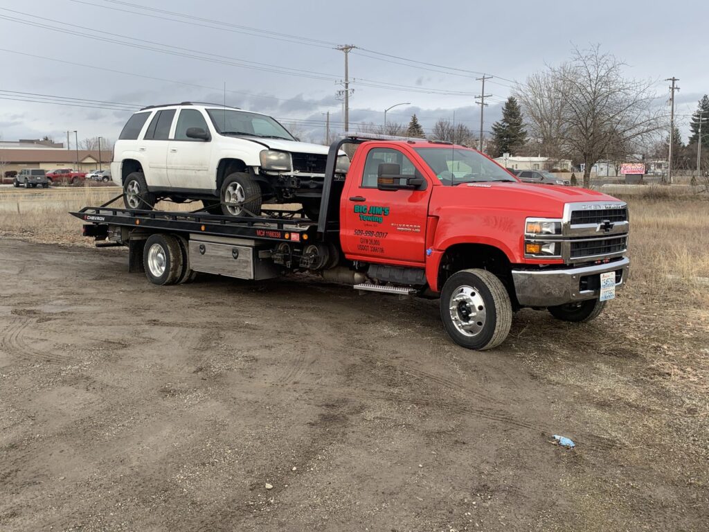 big jims tow truck on the road towing a vechicle in Spokane washington